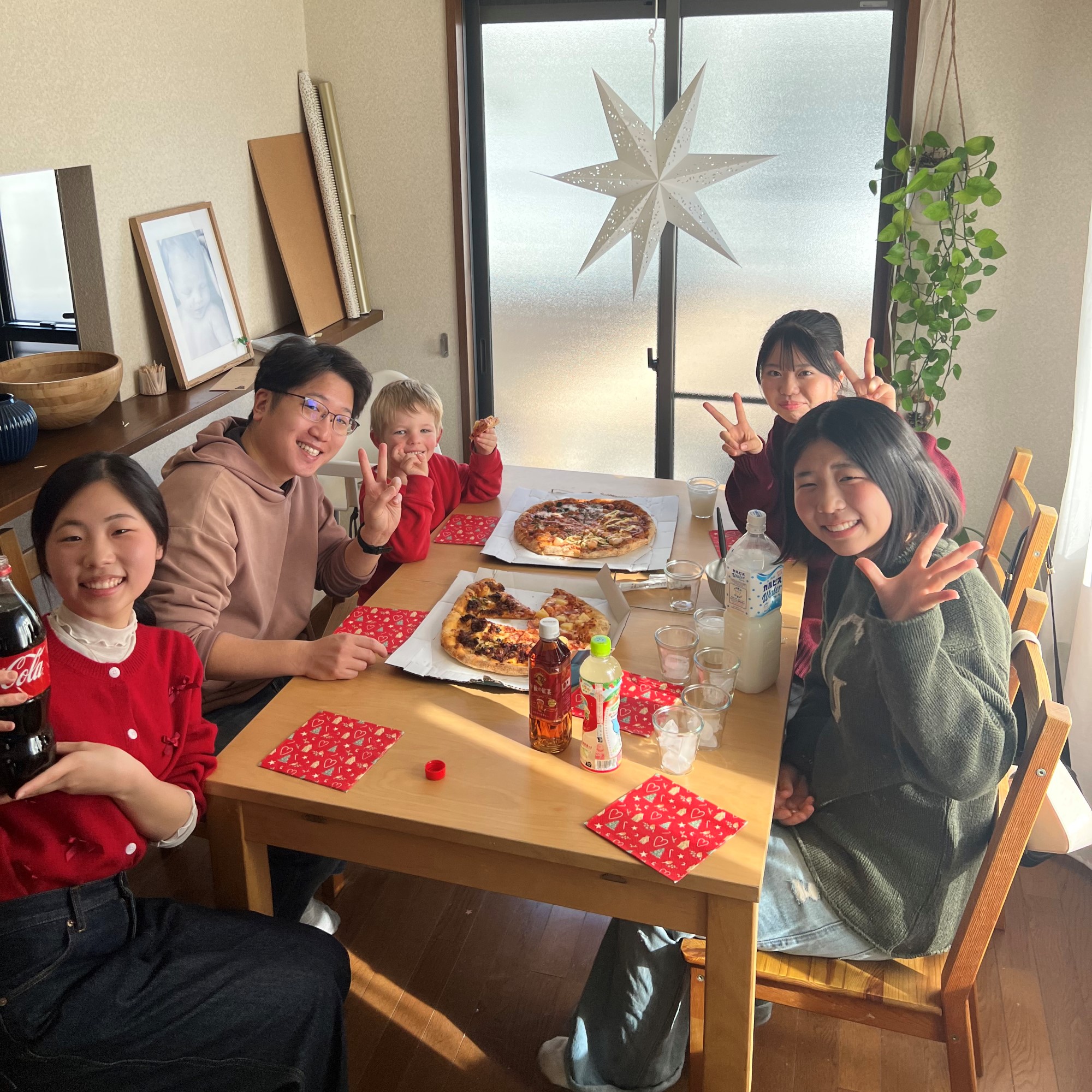 Barn og voksne spiser pizza i hjemmet