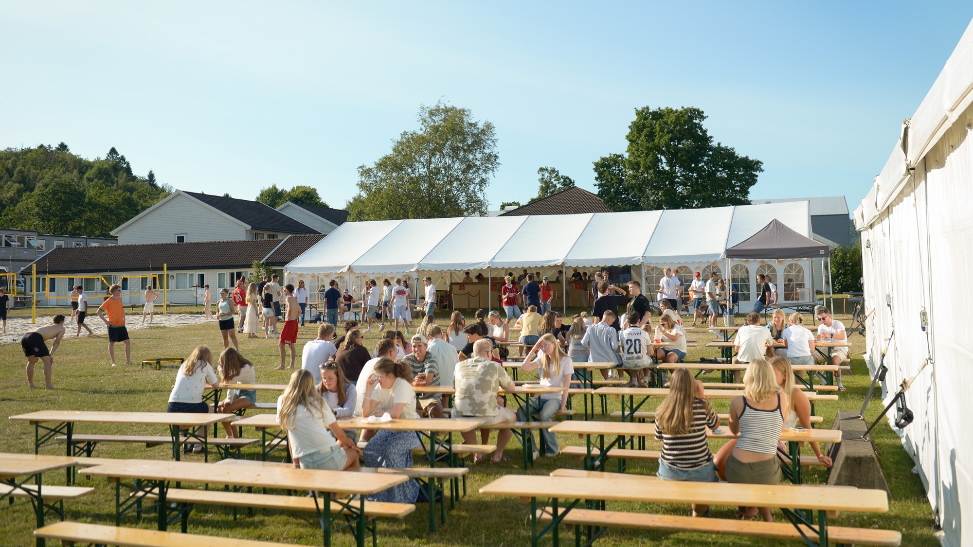 Uteområde med bord og festivaltelt