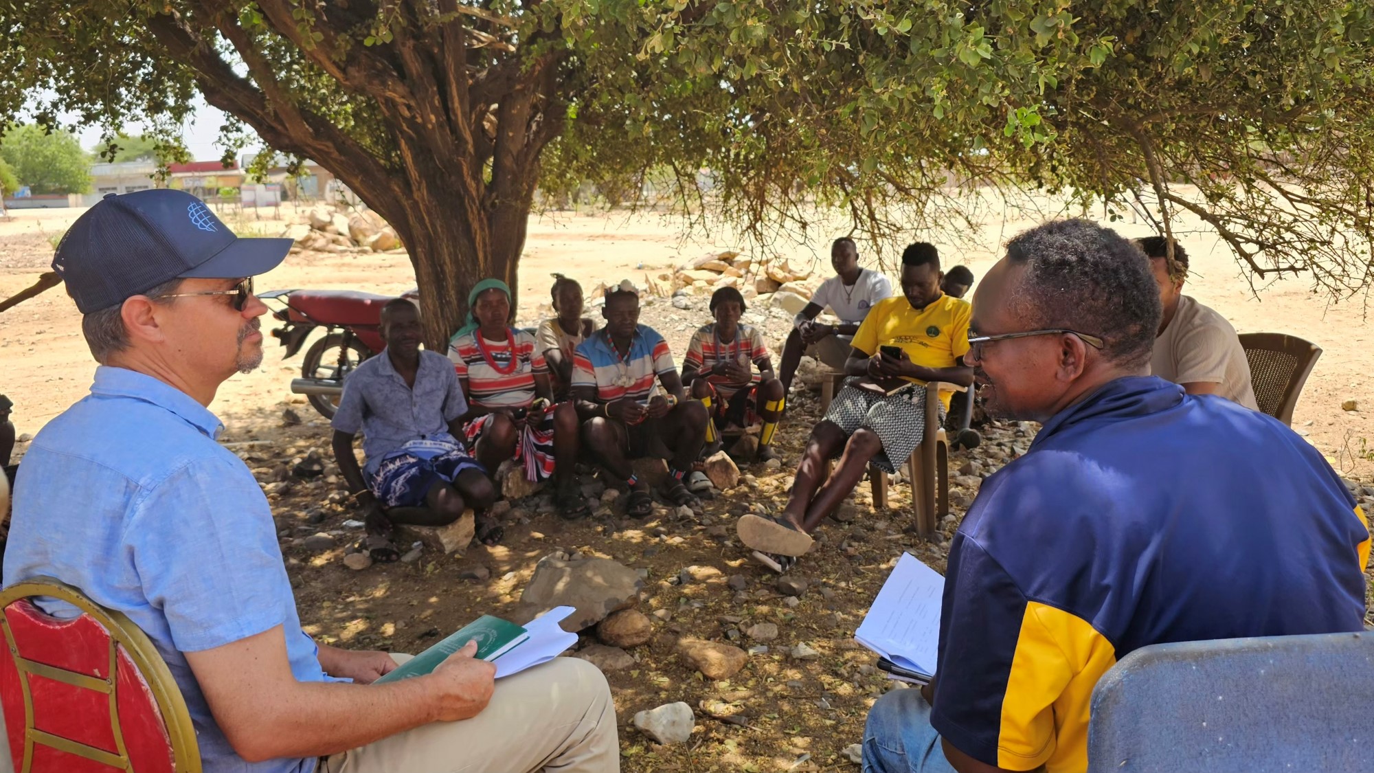 Hans Ovar og Abraham Anjulo i samtale med modellbønder i Inchate