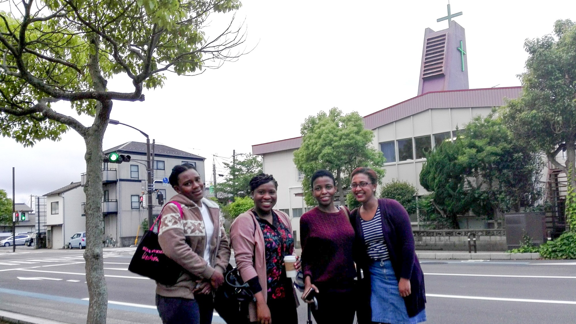 Fire internasjonale kvinner foran kirken