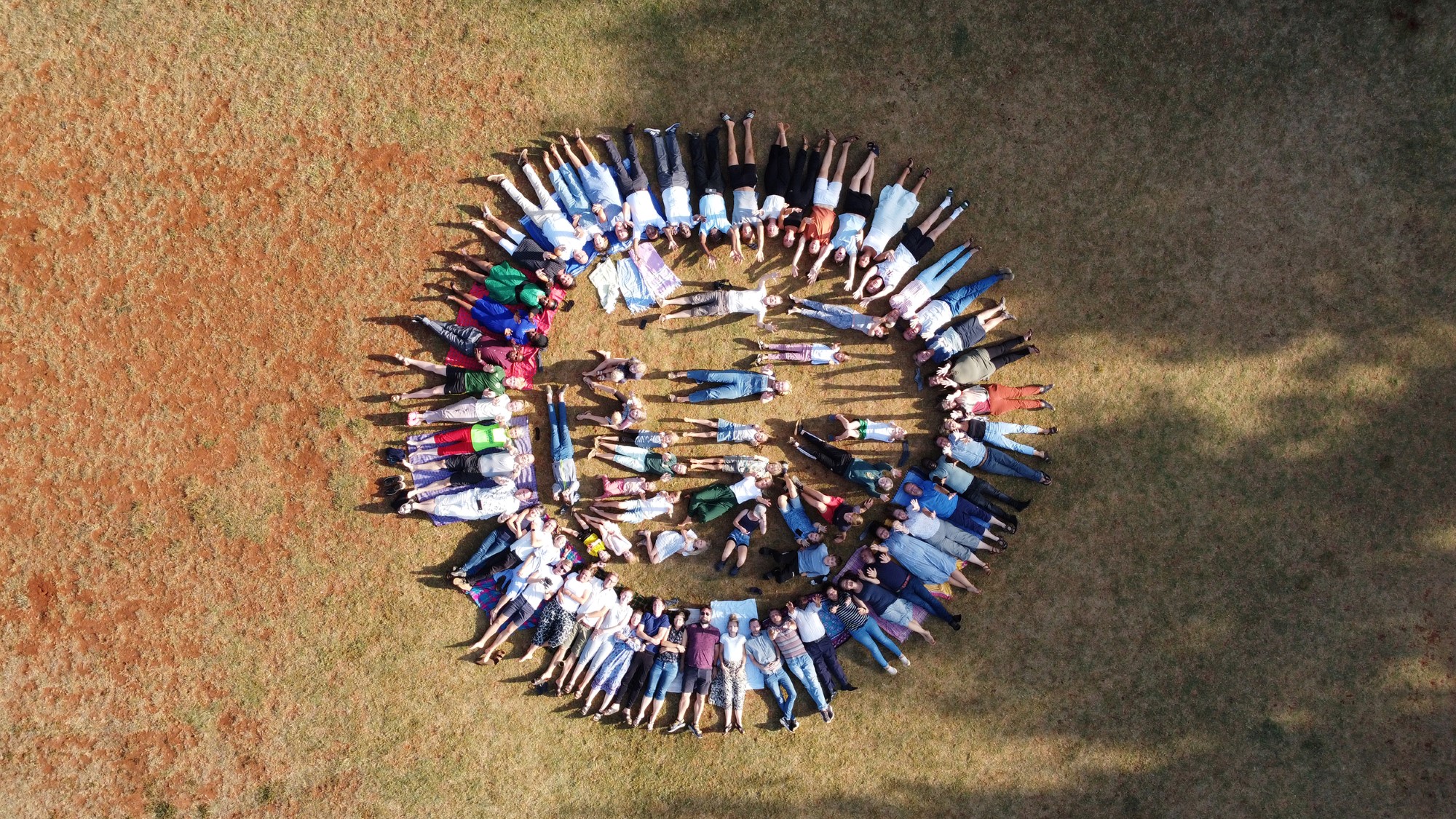 Drone-foto av de fleste utsendingene liggende i sirkel på bakken