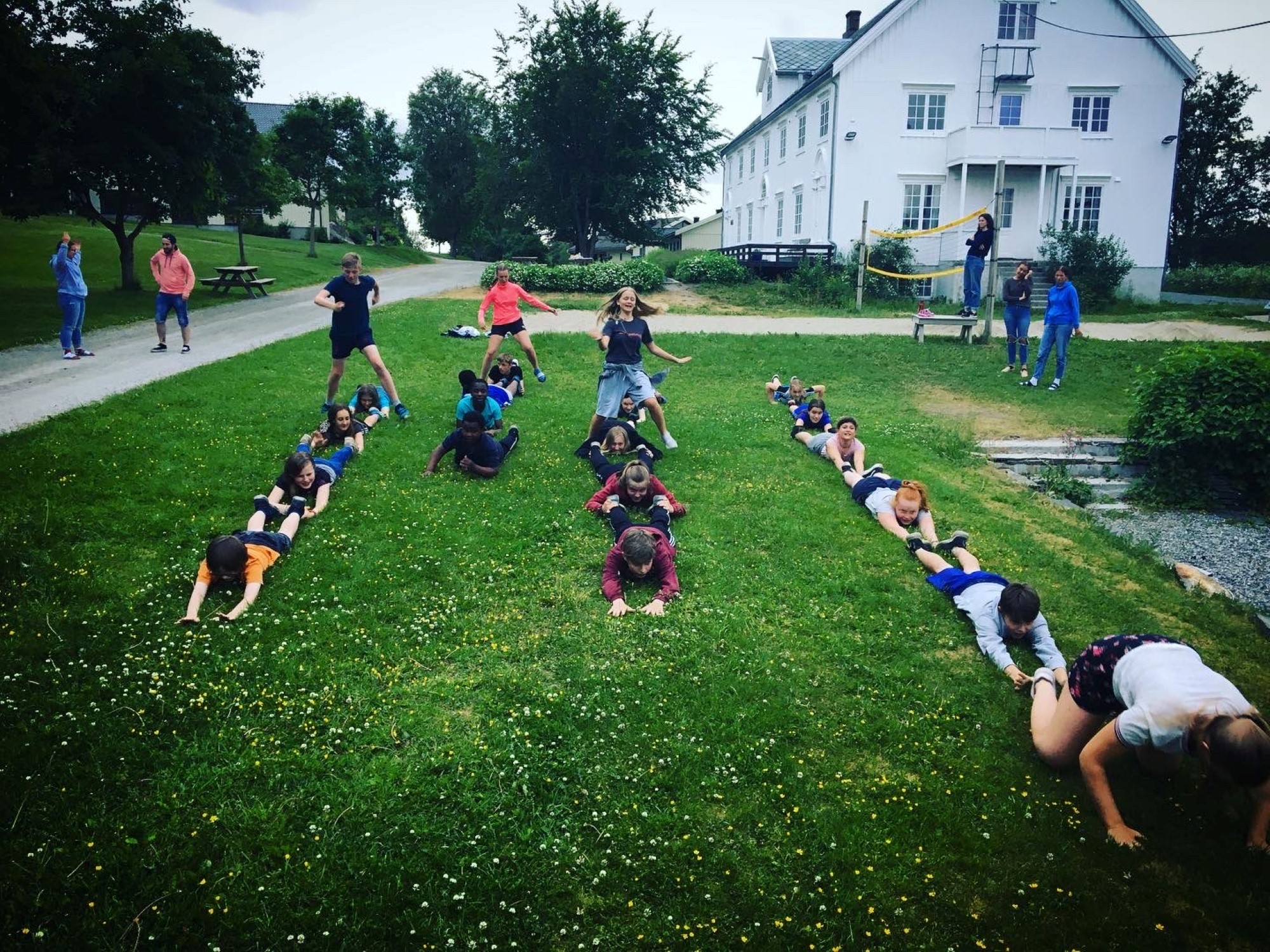 Ungdommer i leik på gressplen