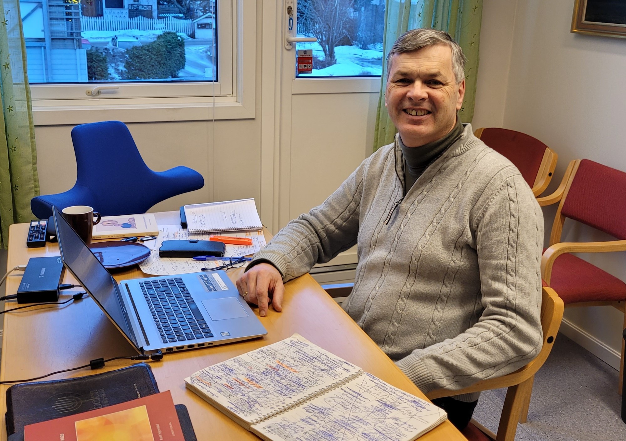 Smilende mann ved kontorpult