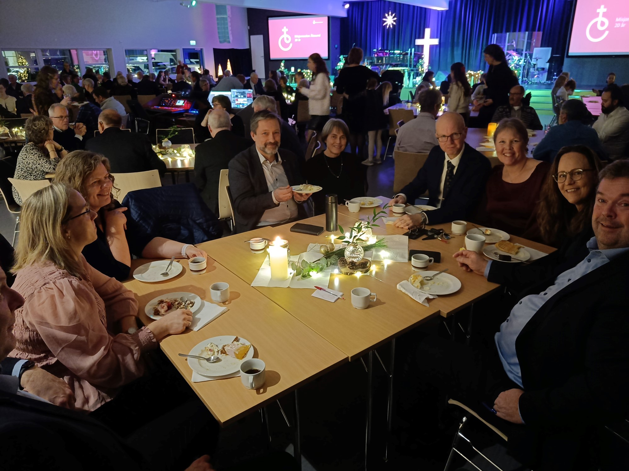 Bildet viser smilende mennesker rundt et bord