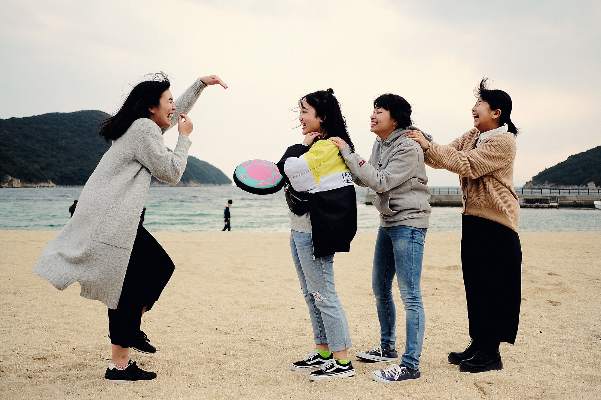 Unge japanske kvinner leker på stranden.