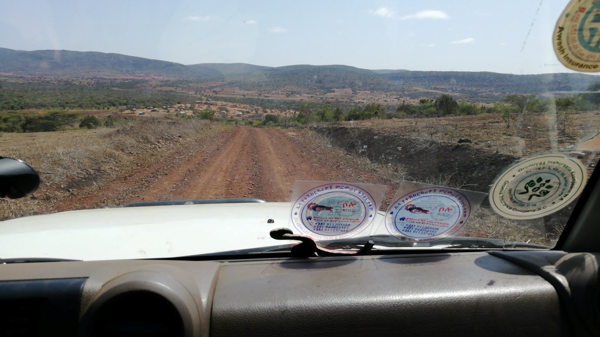 Dashbord i bil og utsikt over etiopisk landevei