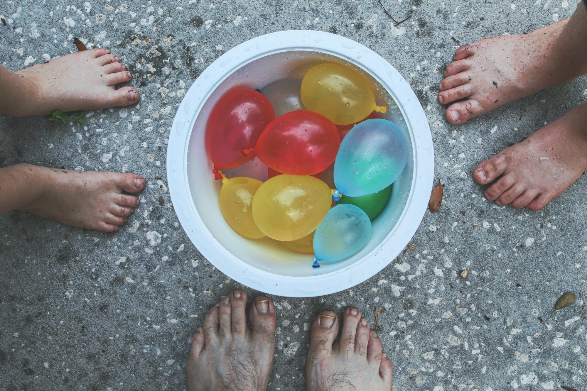 Barneføtter ved bolle med vannballonger
