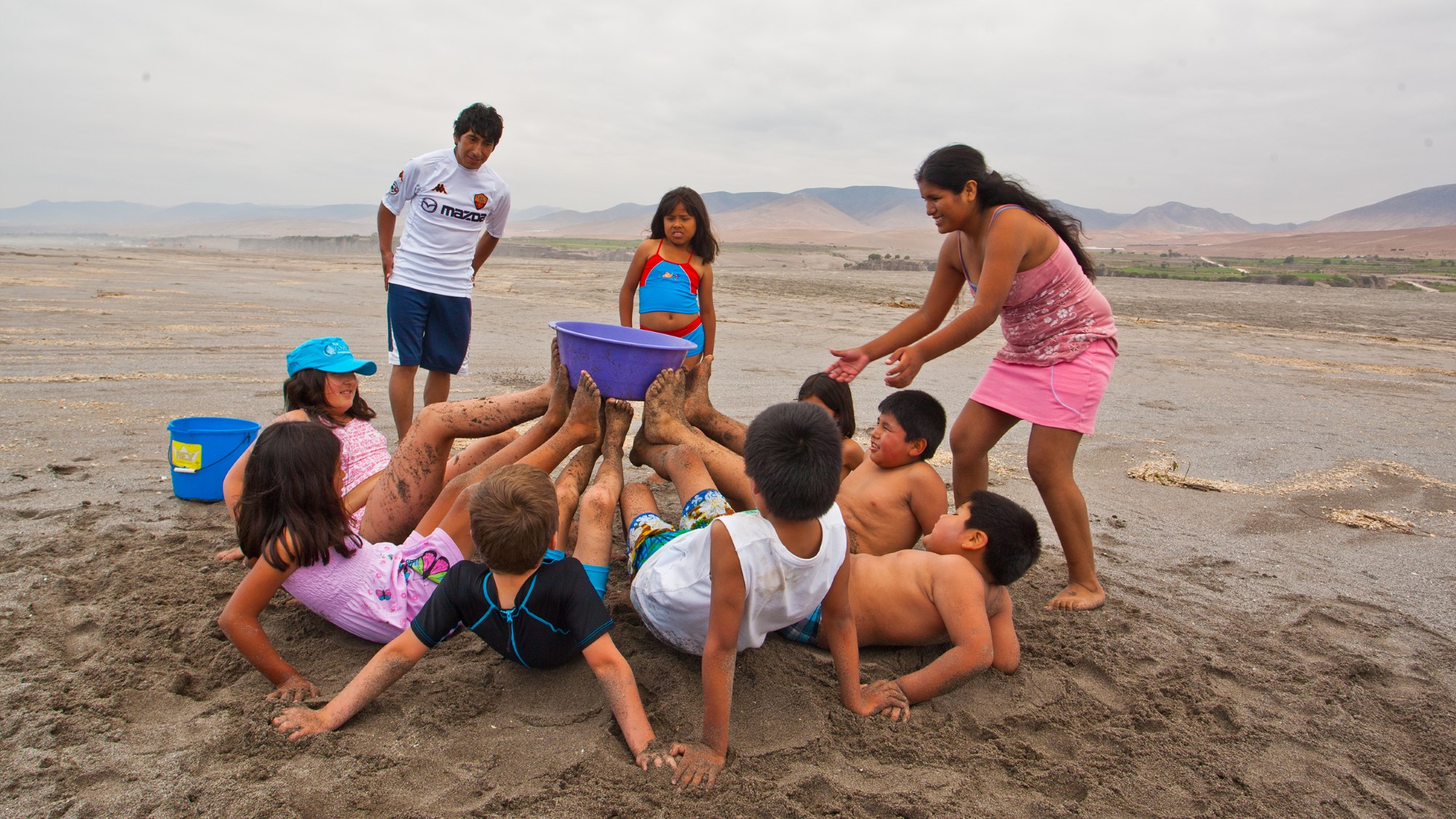 Barn og ungdommer leker på stranden