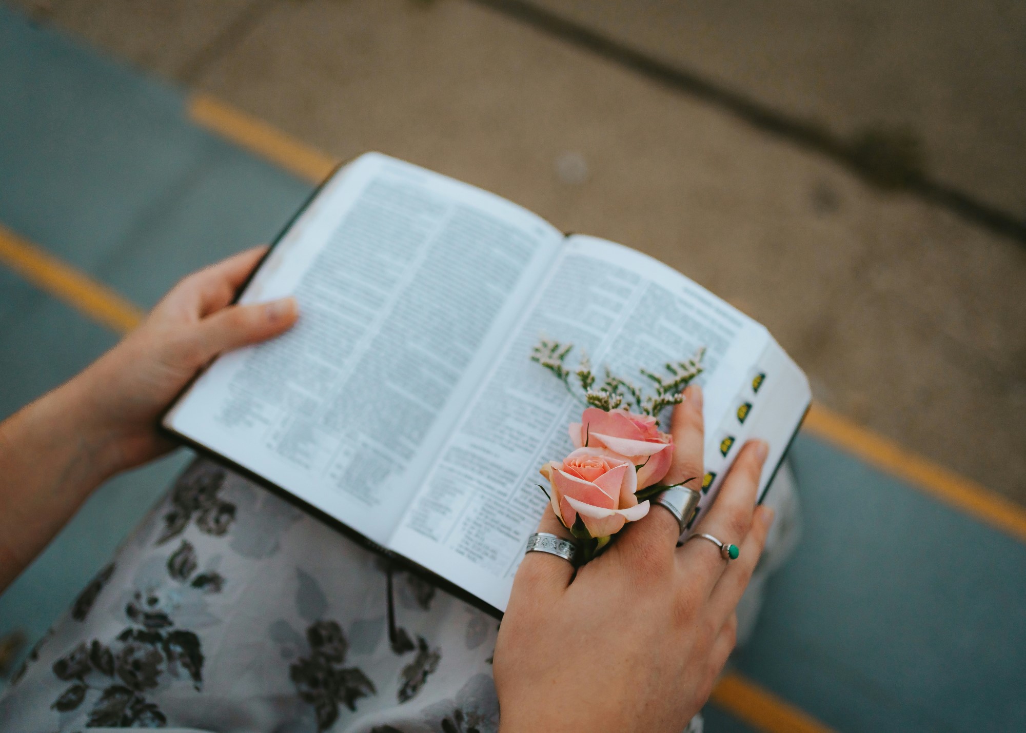 Kvinne med bibel i fanget, og rose i hånden