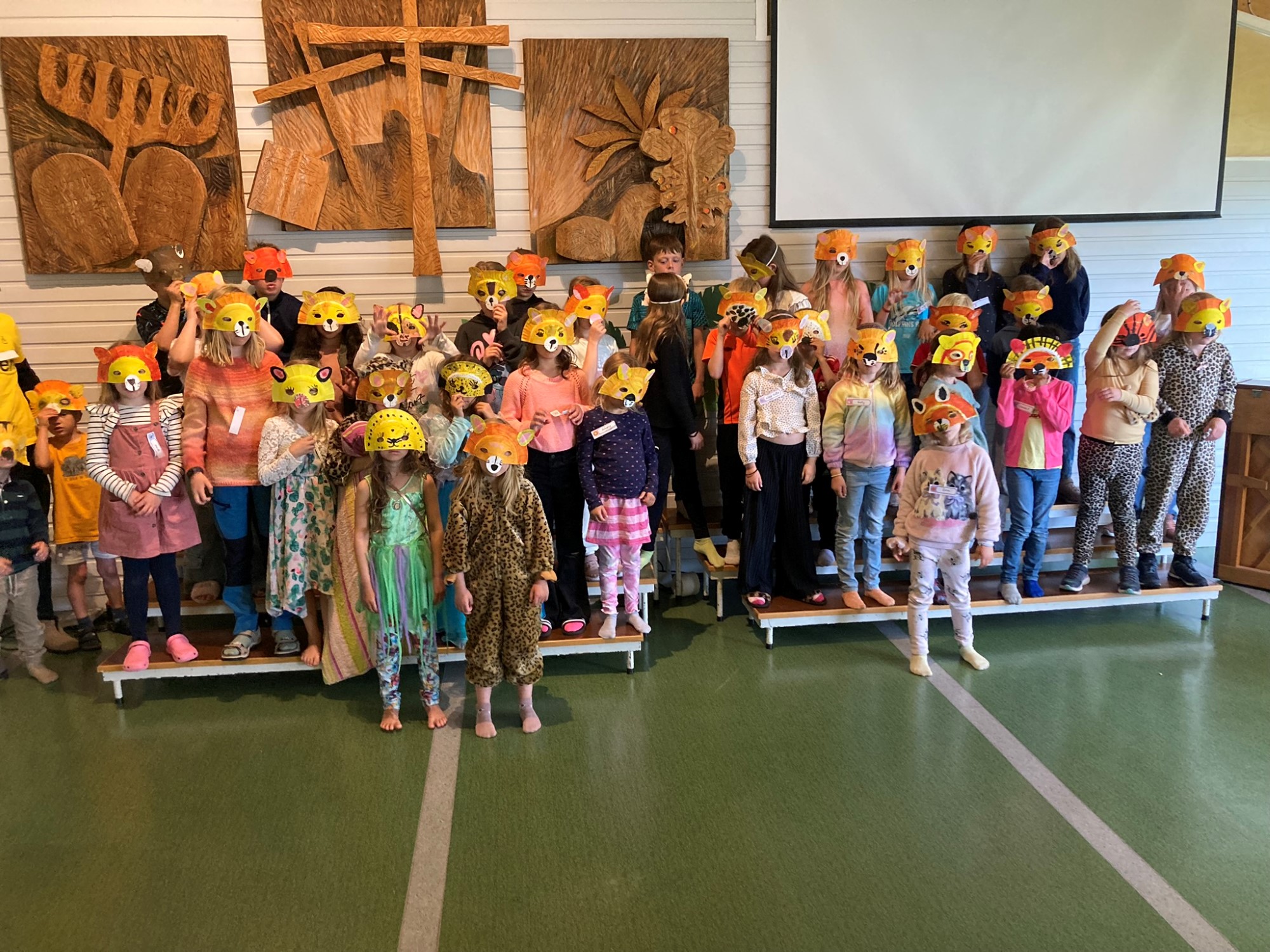 Bildet viser mange barn som står med løvemaske