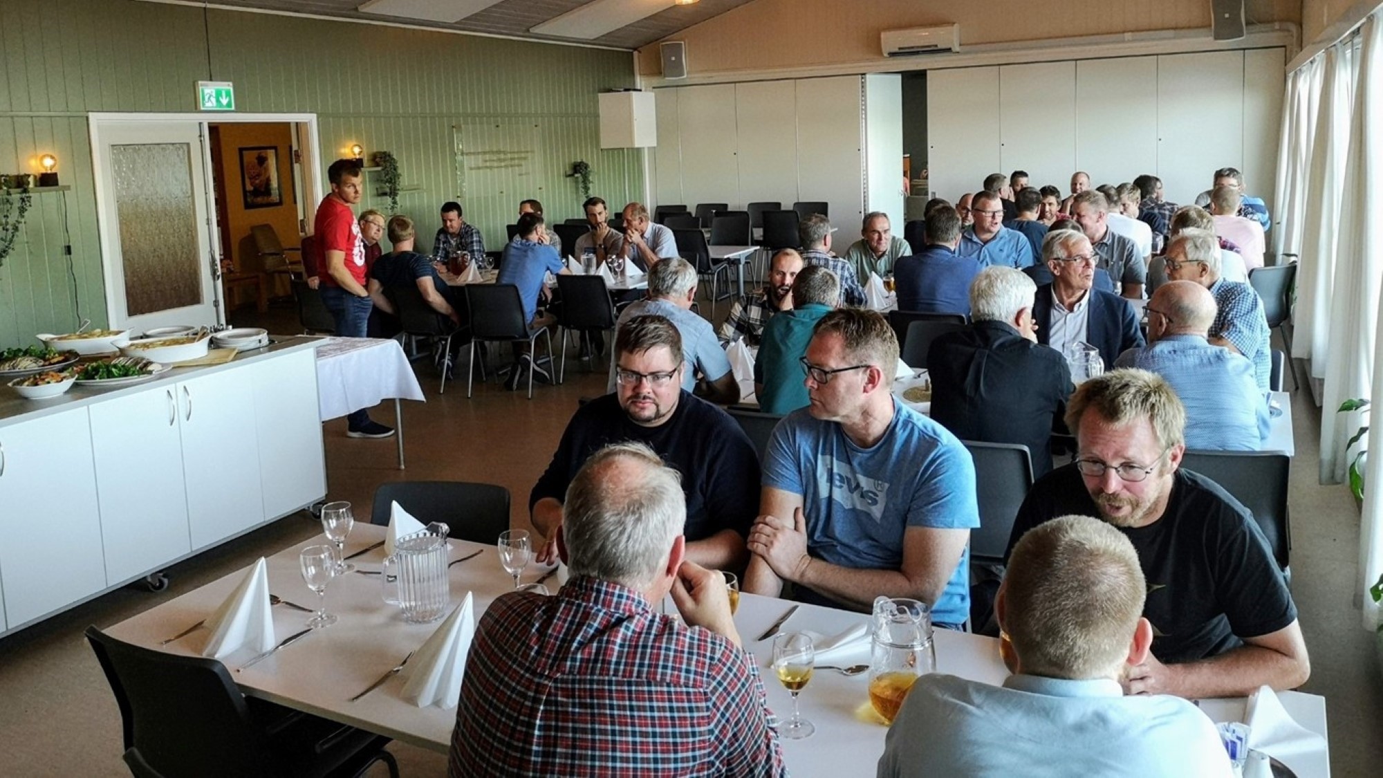 Menn rundt bord, mat og prat