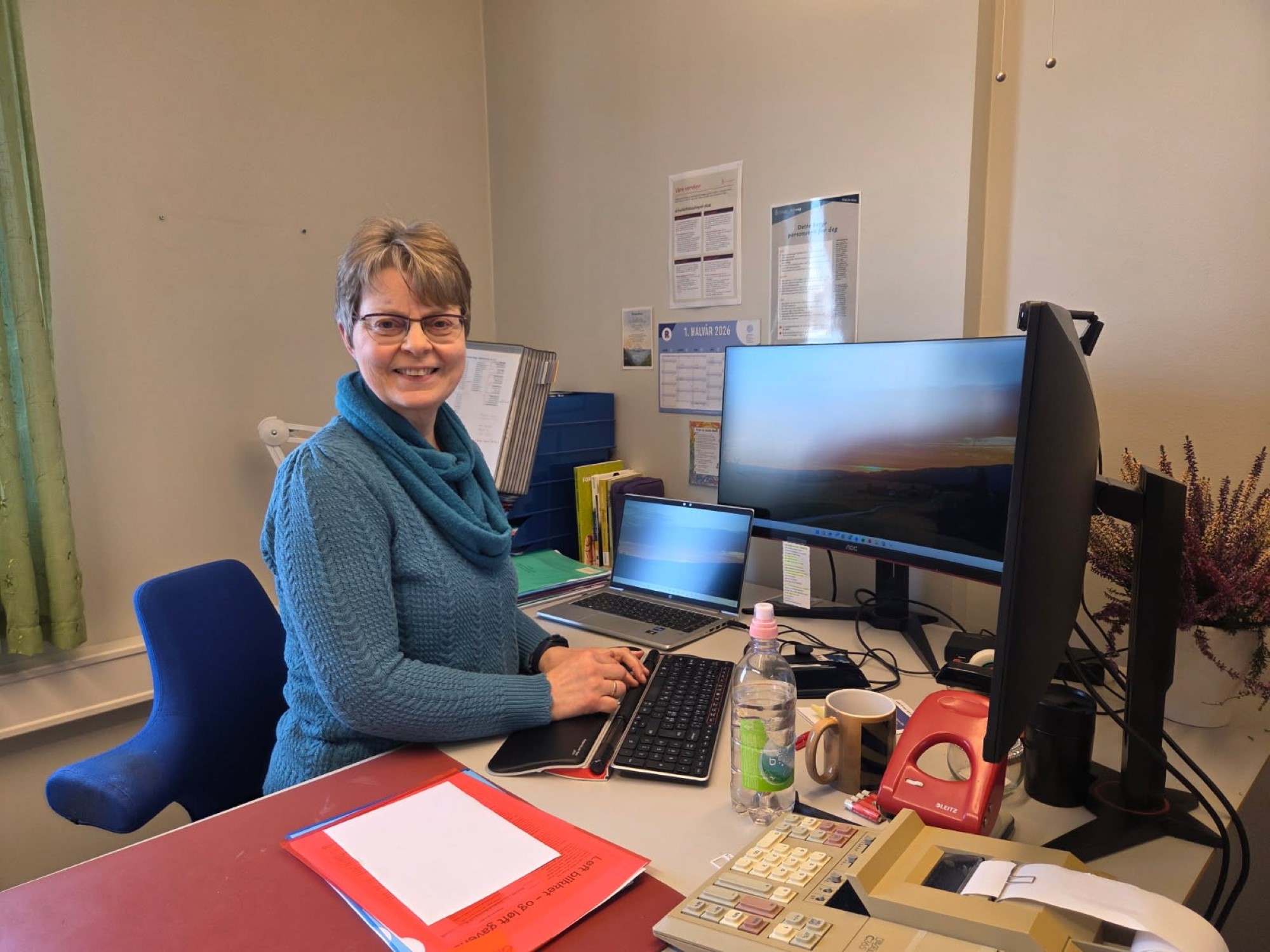 Smilende dame ved kontorpult