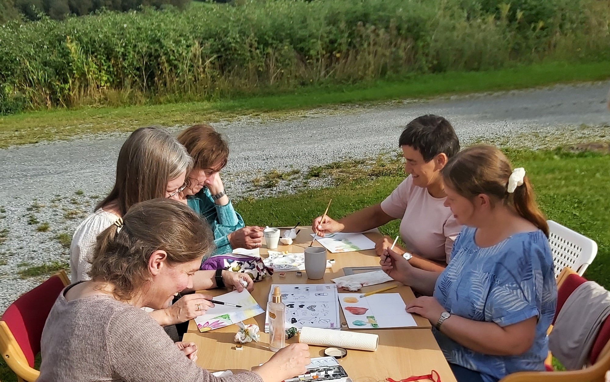 Damer rundt et bord maler akvarellbilder
