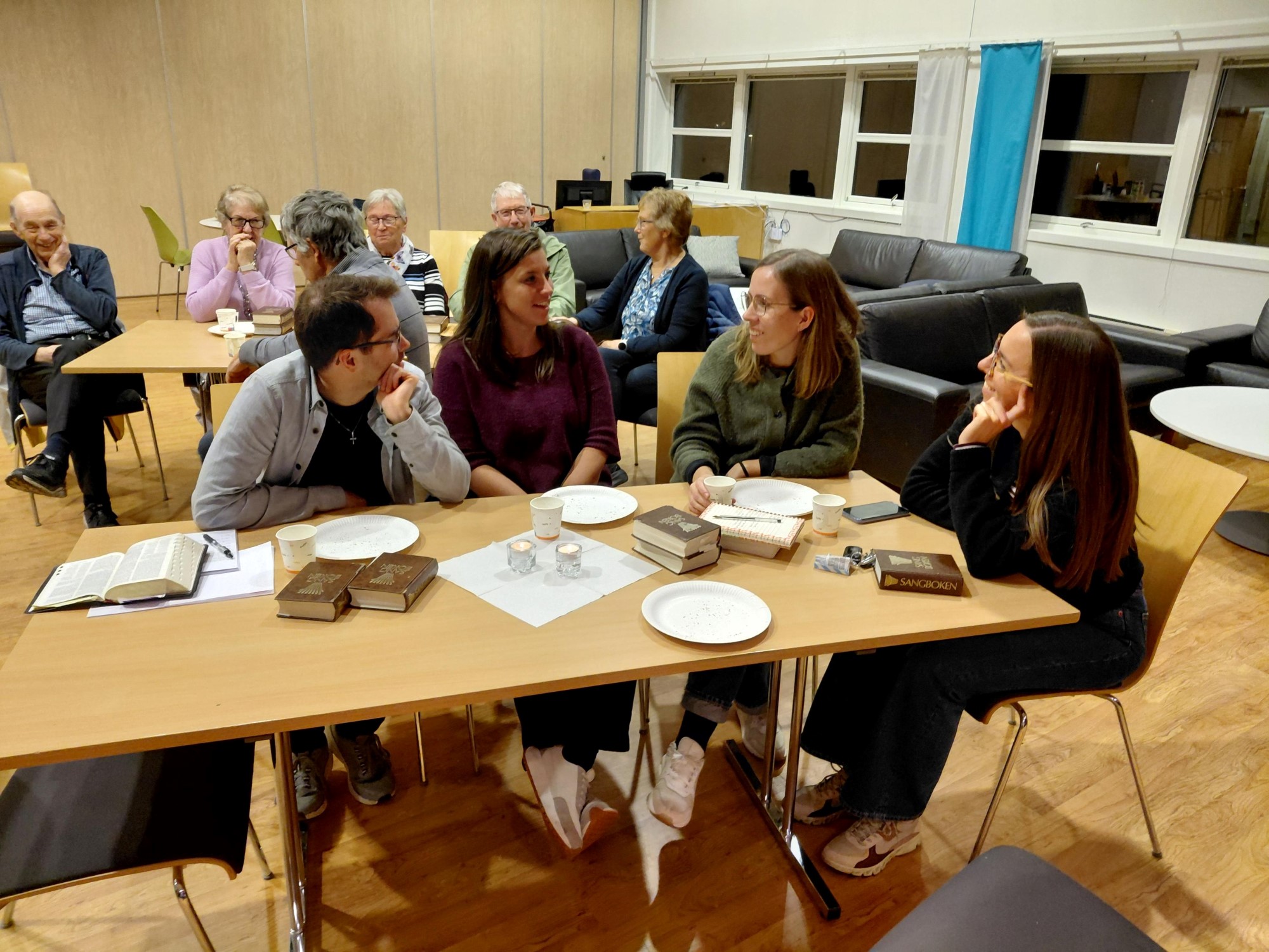 Bildet viser 4 unge mennesker som sitter å samtaler rundt et bord.
