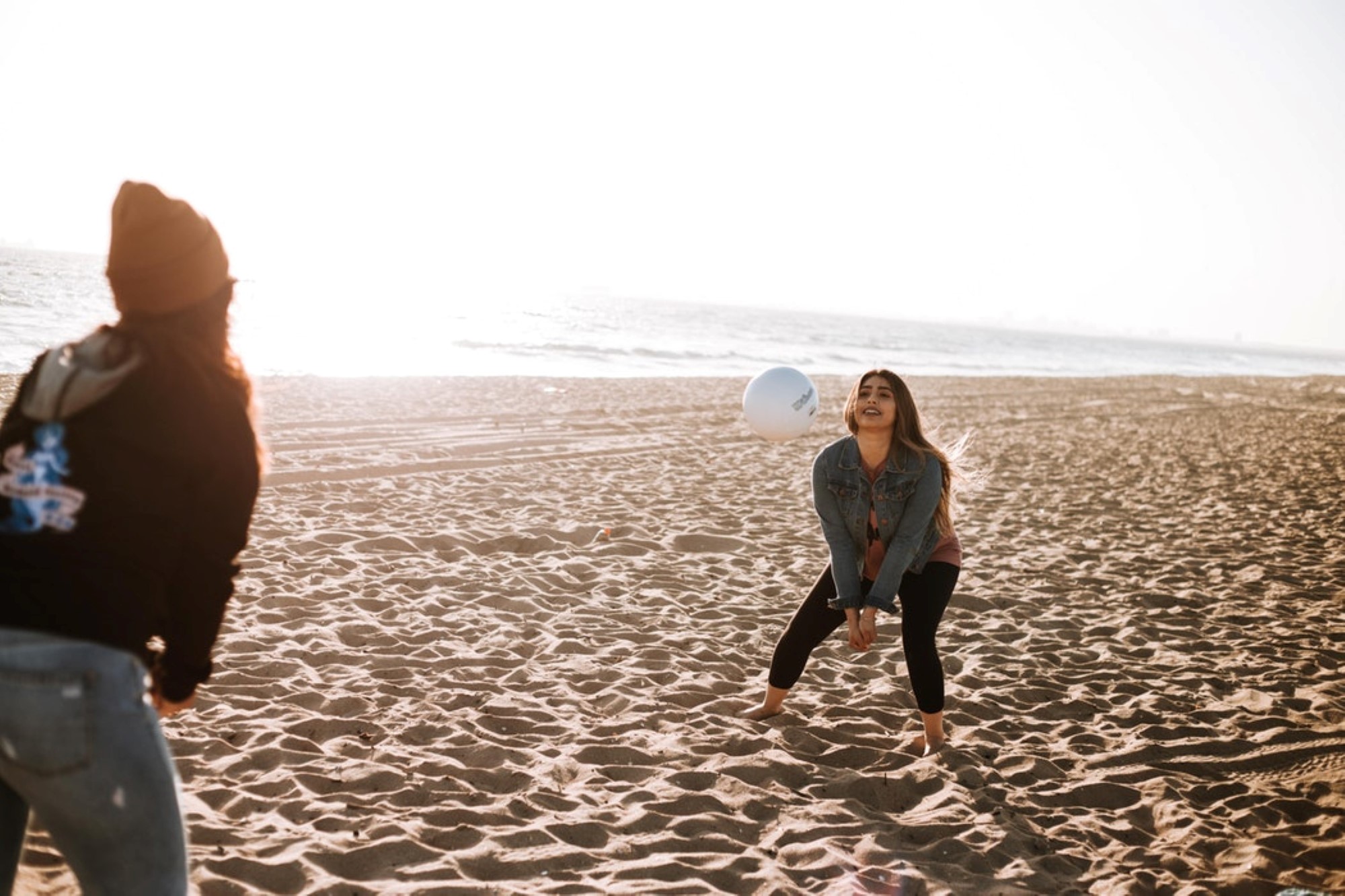 To jenter som spiller vollyeball på stranda
