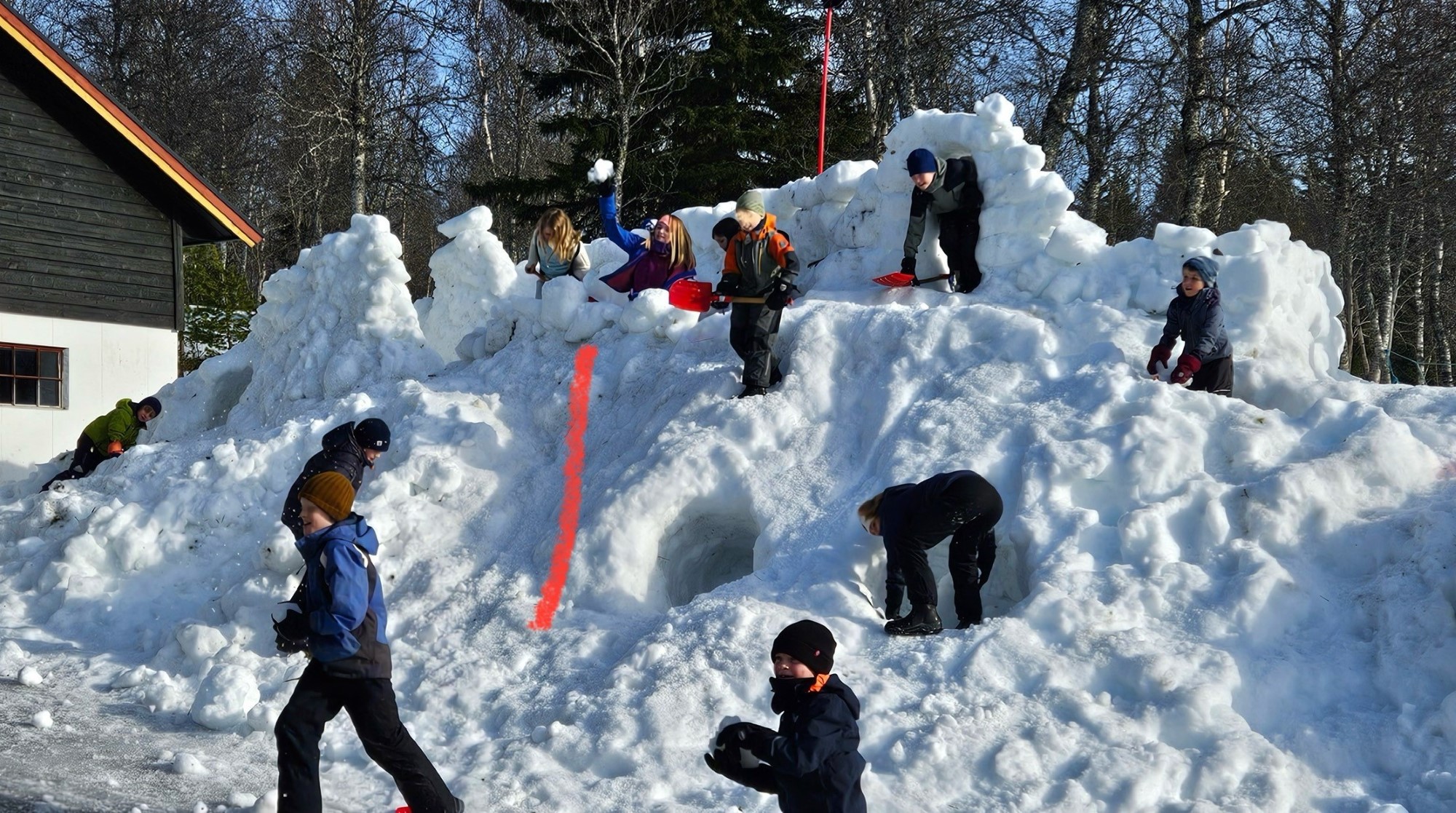 Barn leker i stor snøhaug