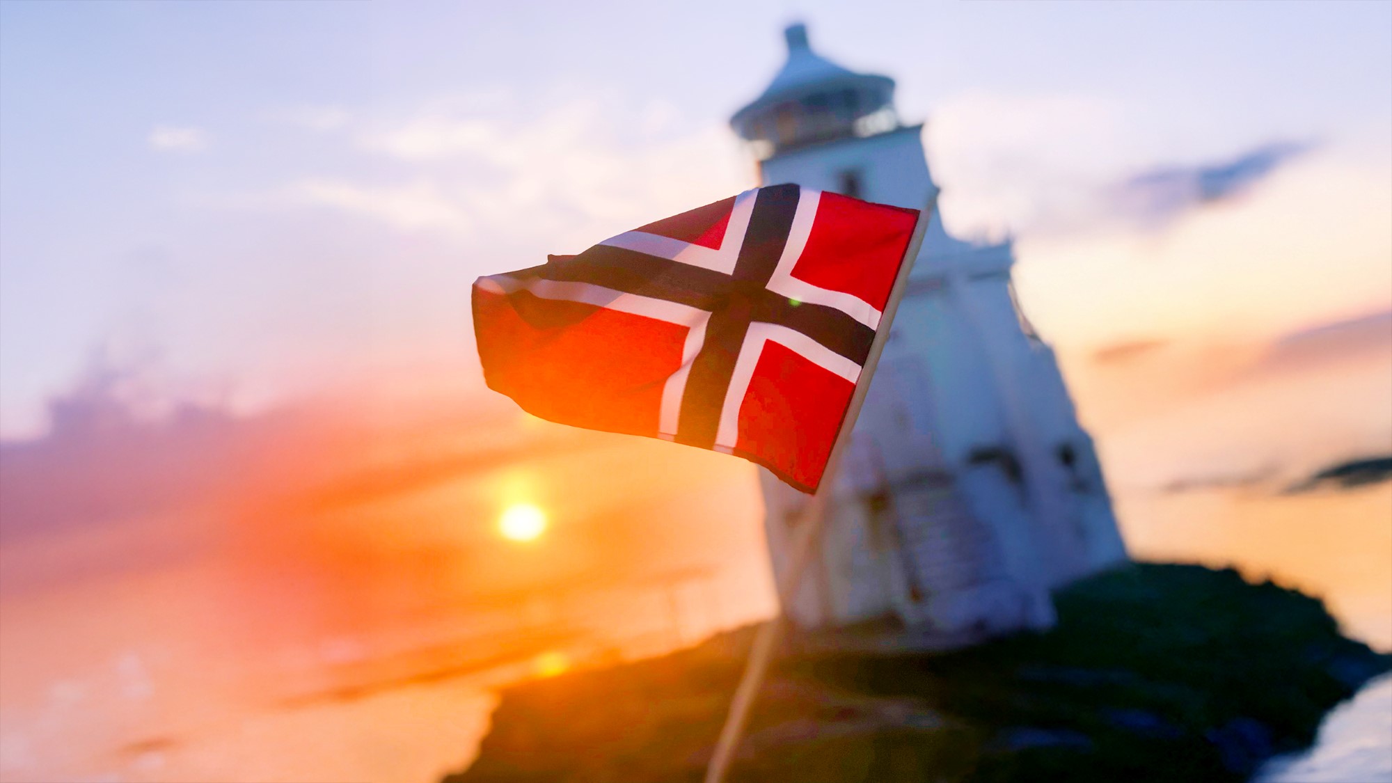 Norsk flagg med diffust sjølandskap i solnedgang