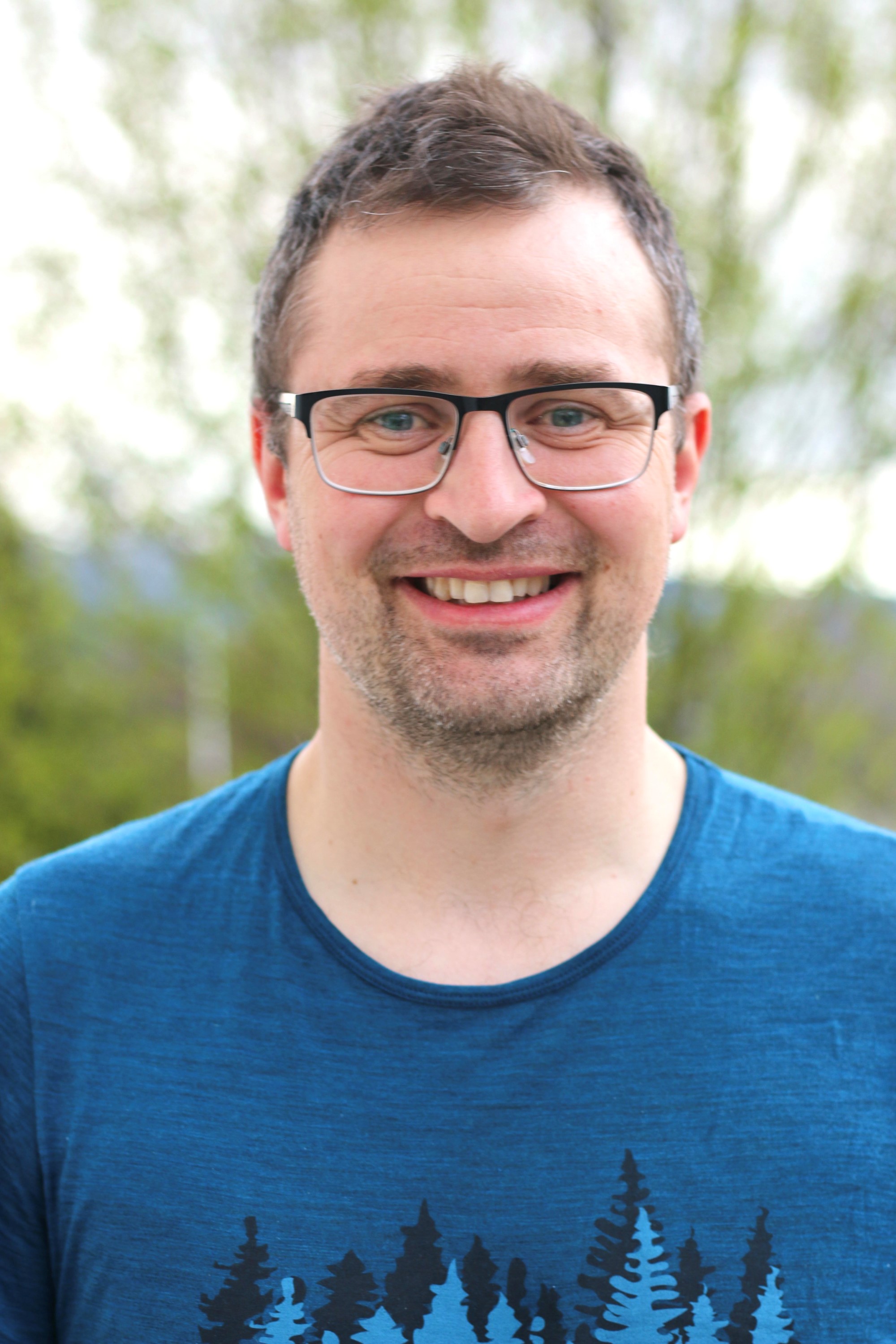 Bildet viser Ole Petter Stenberg. En smilende ung mann med briller.