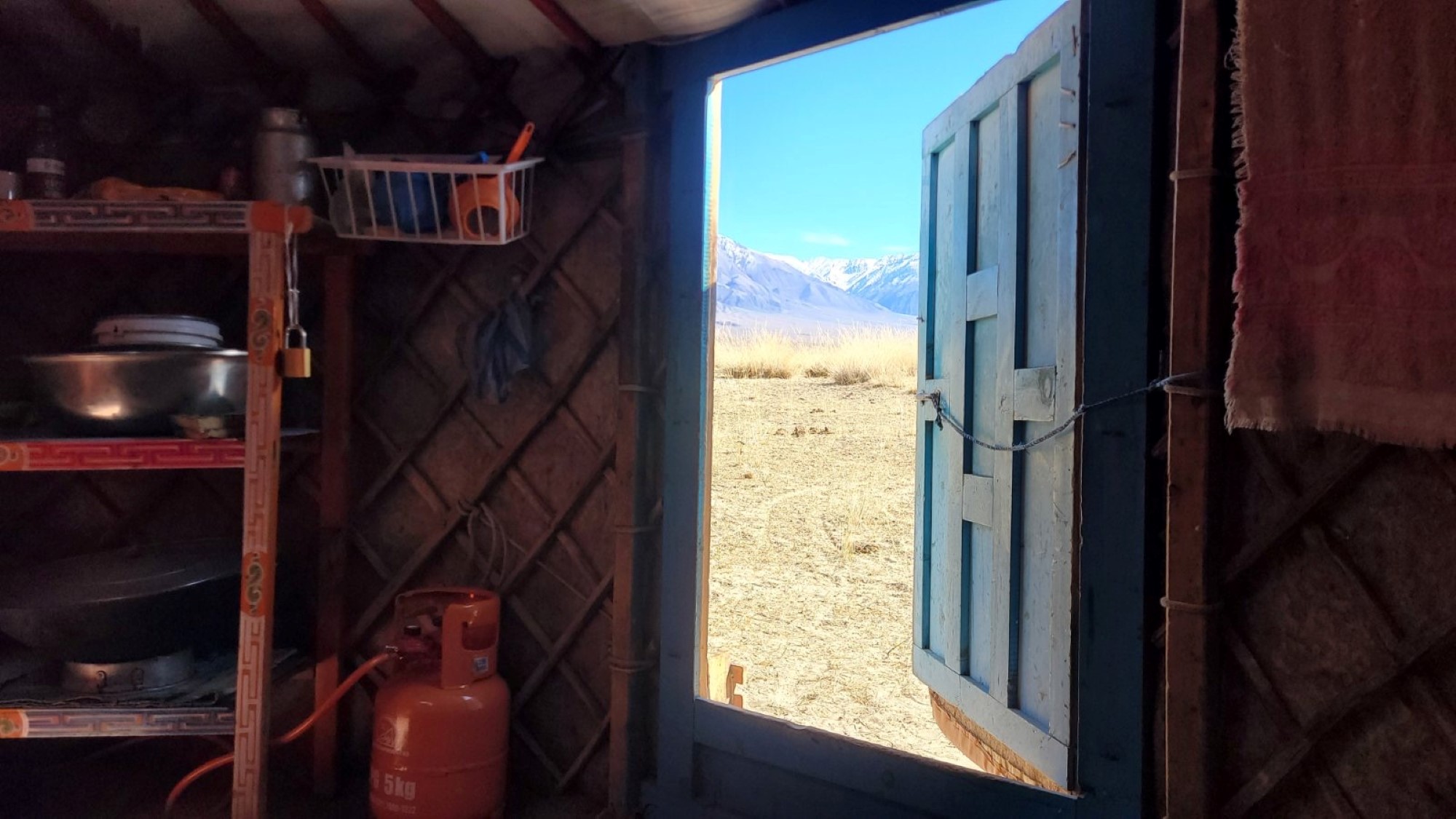 Fra innsiden av en ger, og ut på fjellene på horisonten