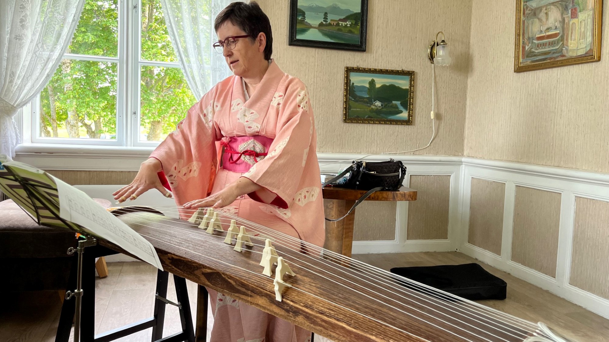 Inger Valbø spiller koto, japansk harpe, iført rosa kimono