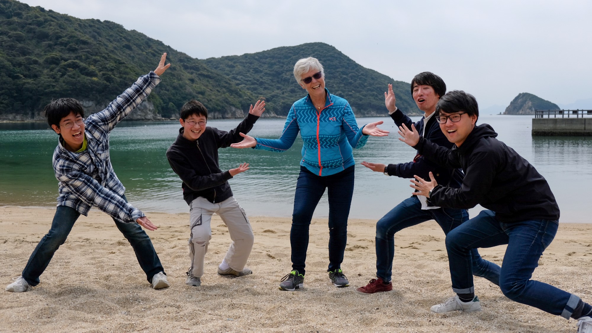 Kari omringet av japanske ungdommer på en strand
