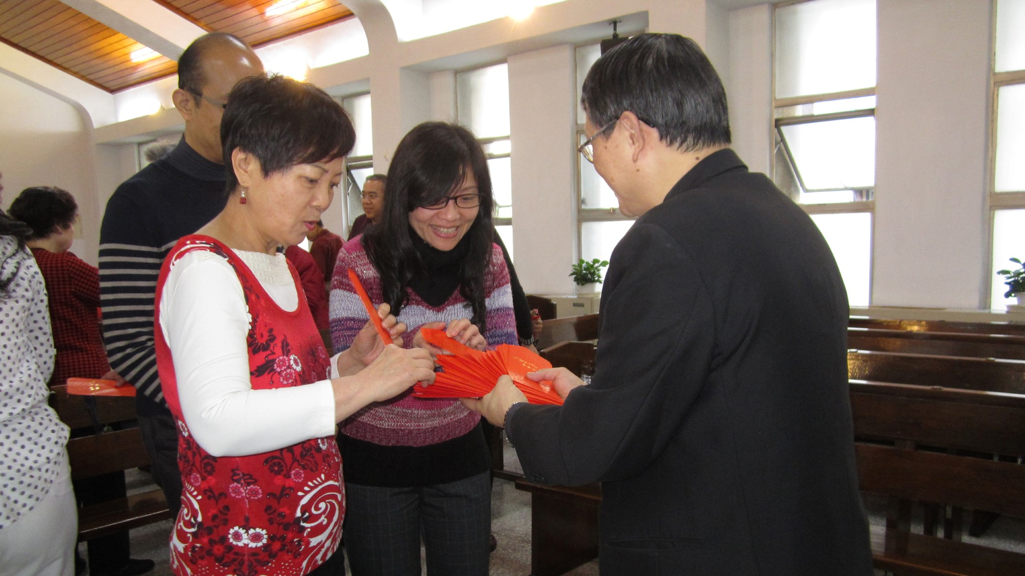 Pastor Du deler ut konvolutter med bibelvers til to kvinner på nyttårsfeiring i 2014