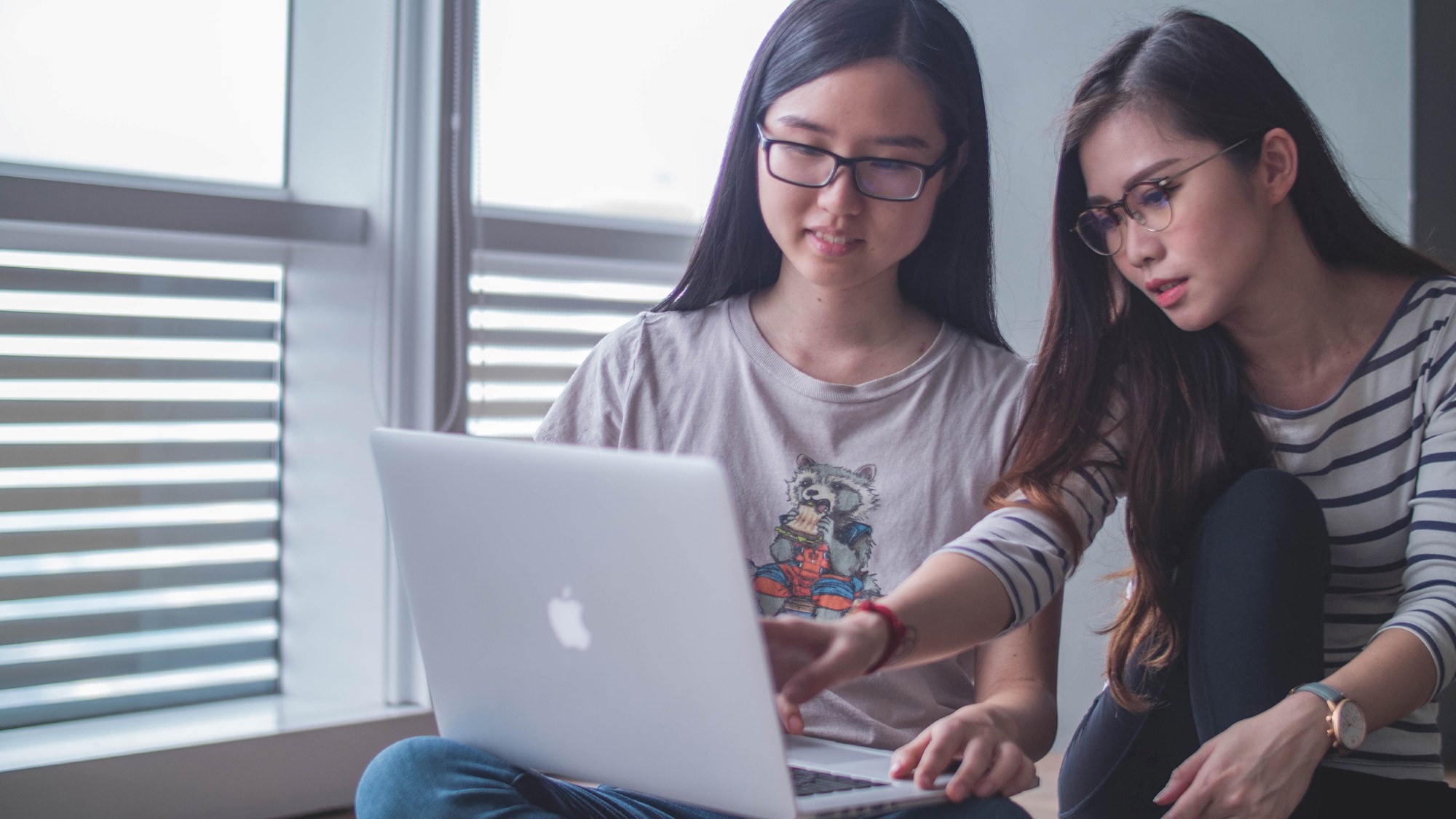 To unge kvinner ser på PC