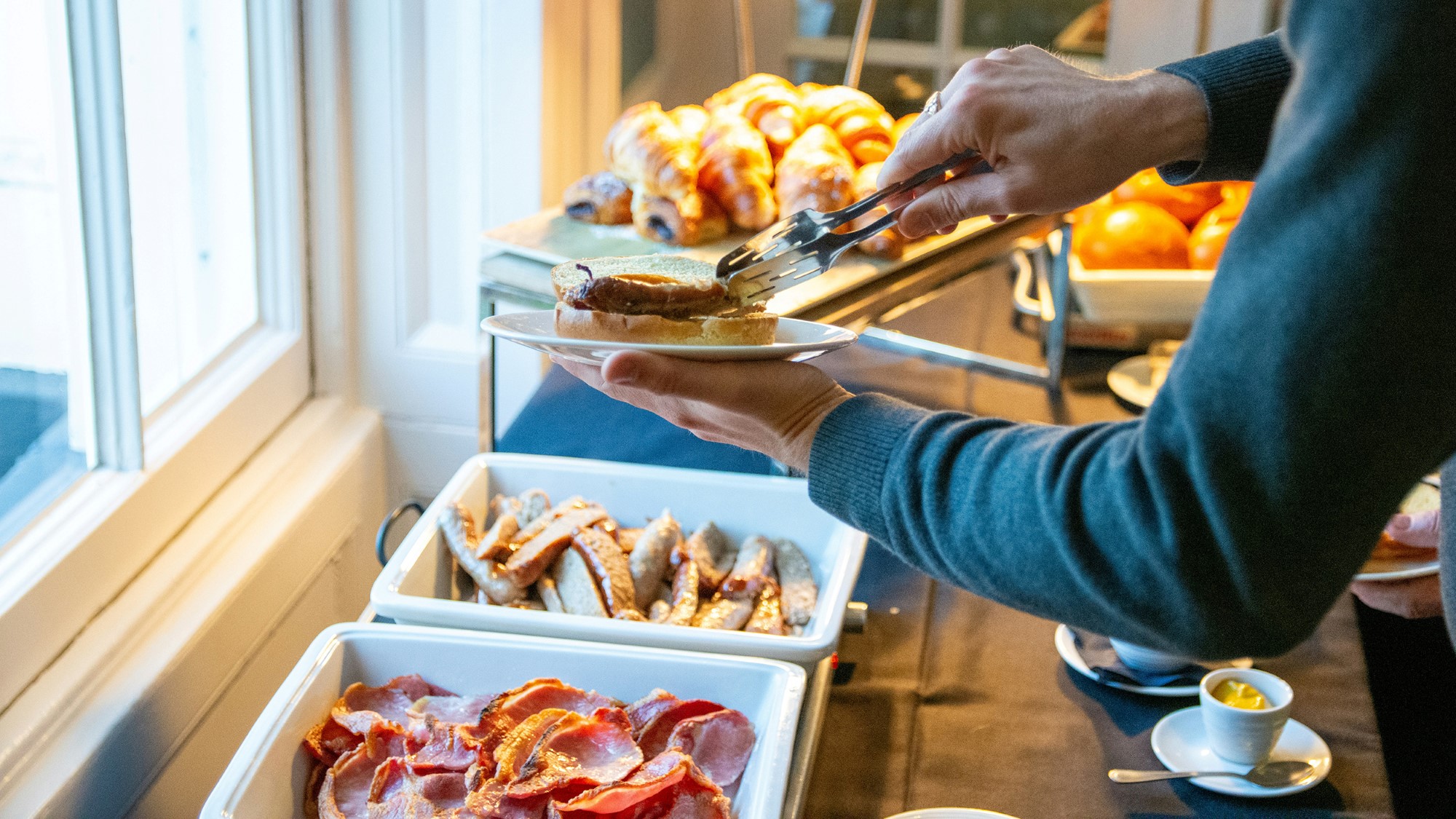 Person forsyner seg av frokostbuffet