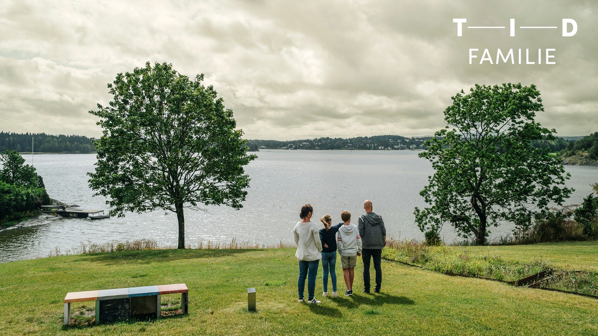 Familie ser ut over norsk landskap med sjø og åser